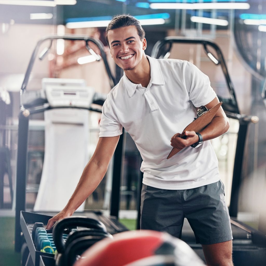 Training, portrait and fitness coach doing inspection of equipment at the gym. Wellness, sport and